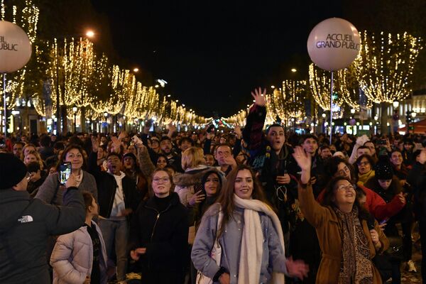 Люди присутствуют на включении рождественской иллюминации на Елисейских полях в Париже. - Sputnik Латвия