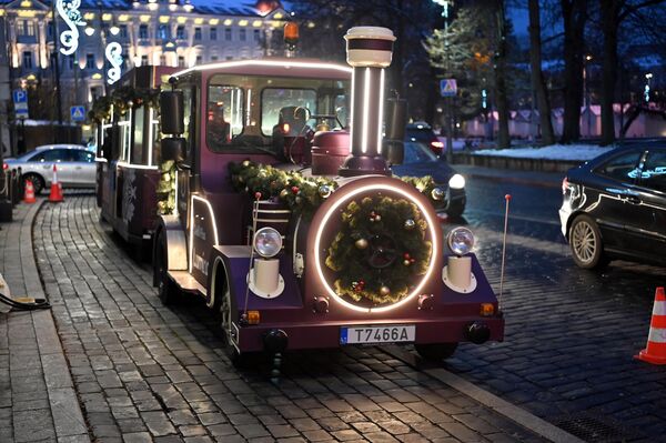 После двухлетнего перерыва в Старый город Вильнюса вернулся Рождественский поезд. Приглашать прокатиться жителей и гостей города по праздничной столице он будет до 8 января. - Sputnik Латвия