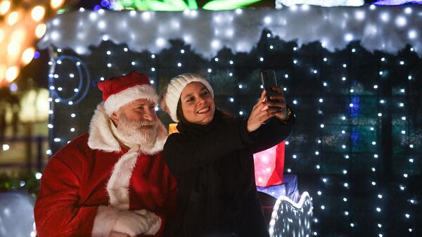 Человек в костюме Санта-Клауса фотографируется с девушкой в Италии  - Sputnik Латвия