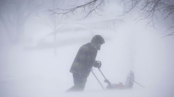 Мужчина убирает снег во время зимнего шторма в Амхерсте, штат Нью-Йорк, 24 декабря 2022 года - Sputnik Латвия