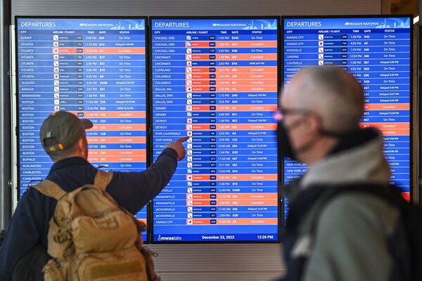 Пассажир смотрит на отмененные рейсы на информационном табло в национальном аэропорту Рейгана во время  зимнего шторма в Арлингтоне, штат Вирджиния, 23 декабря 2022 года. - Sputnik Латвия