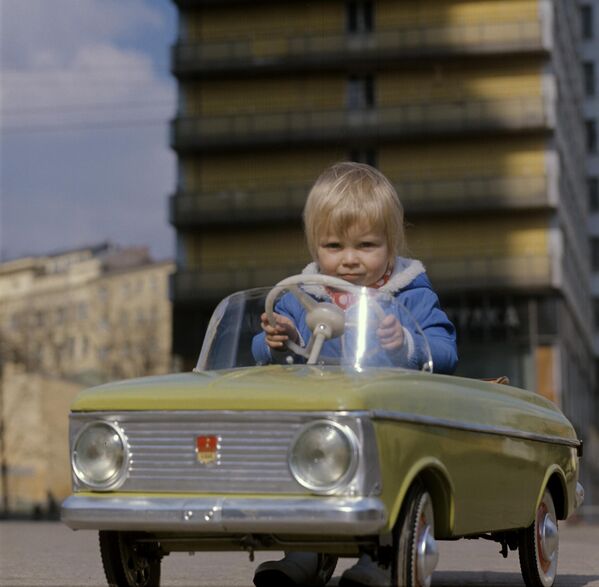 Счастливый ребенок и детский автомобиль на Калининском проспекте. - Sputnik Латвия