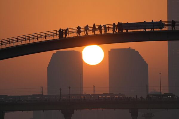 Люди наблюдают за первым восходом солнца в 2023 году Сеуле, Южная Корея, в воскресенье, 1 января. - Sputnik Латвия