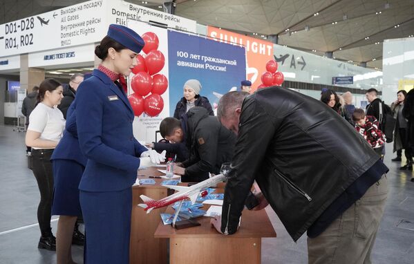 Сотрудники аэропорта проводят праздничную лотерею на мероприятиях в честь празднования 100-летия гражданской авиации в аэропорту Пулково - Sputnik Латвия