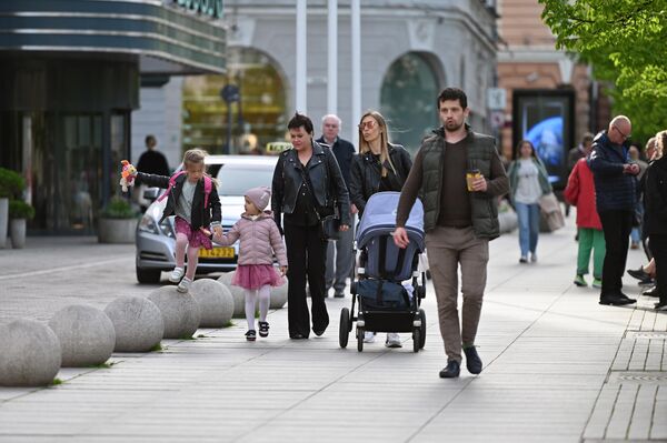 Жители семьями выходят на прогулку по центру города.  - Sputnik Латвия
