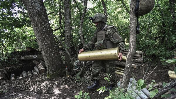 Военнослужащий ВС РФ подносит снаряд для САУ Гиацинт-С в зоне спецоперации - Sputnik Латвия