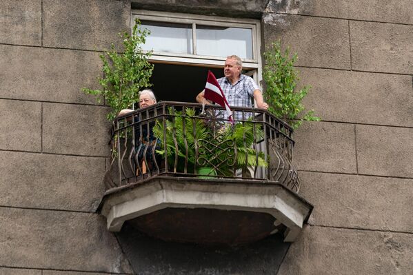 Жители Риги наблюдают за шествием с балконов. - Sputnik Латвия