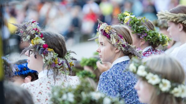 Латышские девушки в народных костюмах и с венками на головах на Празднике песни и танца  - Sputnik Латвия