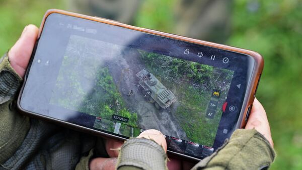 Военнослужащий ВС РФ демонстрирует работу БПЛА на купянском направлении - Sputnik Латвия