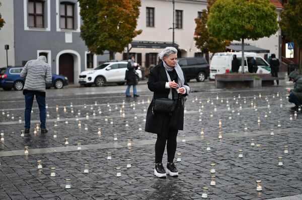 Организаторы акции по периметру всей площади выставили и зажгли свечи белого цвета. - Sputnik Латвия