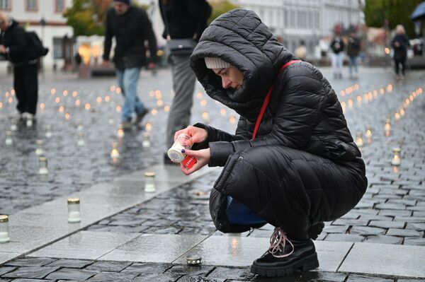 На фото: жители Вильнюса зажигают свечи в память о погибших в Израиле. - Sputnik Латвия