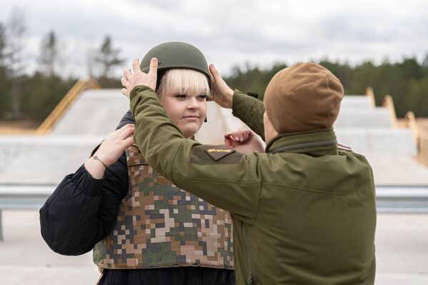 Военнослужащий латвийской армии помогает надеть каску - Sputnik Латвия