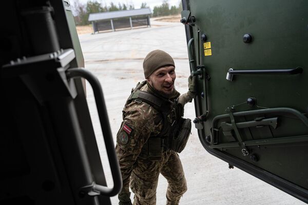 Латвийский военнослужащий знакомит участников фотоконкурса с возможностями бронетранспортера Patria 6x6 - Sputnik Латвия