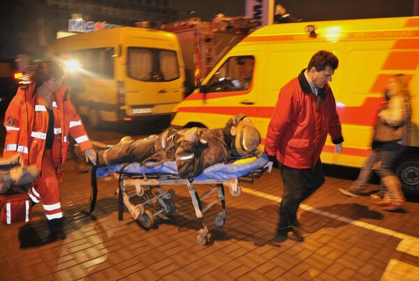Медики скорой помощи везут носилки с сотрудником пожарно-спасательной службы, пострадавшим при разборе завалов от обрушения крыши в ТЦ Maxima.  - Sputnik Латвия
