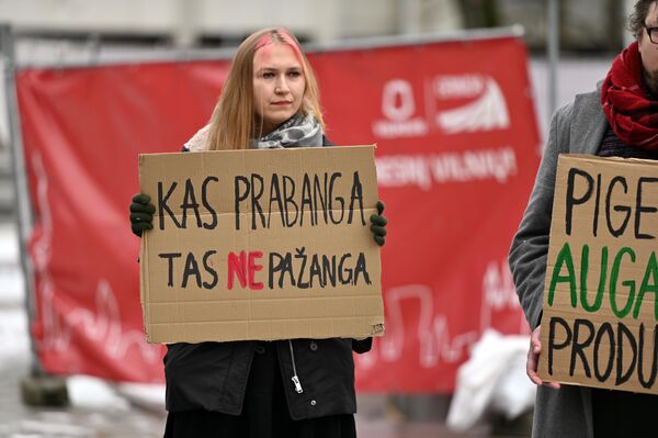 На фото: участница акции держит плакат с надписью: &quot;Что роскошь — то не прогресс&quot;. - Sputnik Латвия