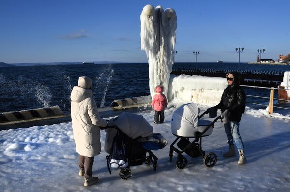 Женщины с детьми гуляют в морозный день на обледенелой набережной Спортивной гавани во Владивостоке - Sputnik Латвия
