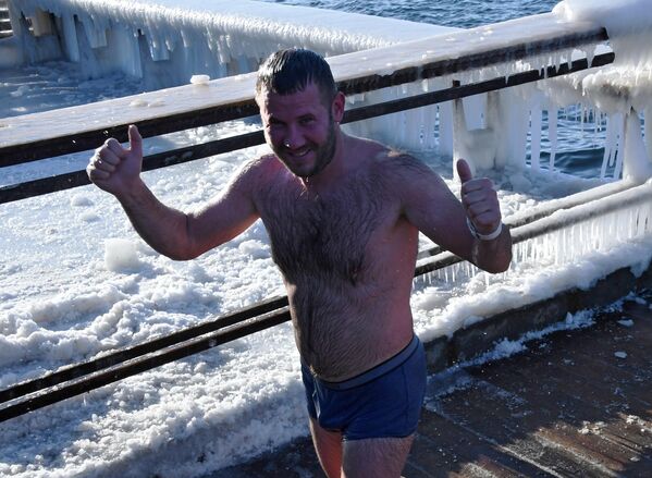 Мужчина после купания в морозный день на обледенелой набережной Спортивной гавани во Владивостоке - Sputnik Латвия