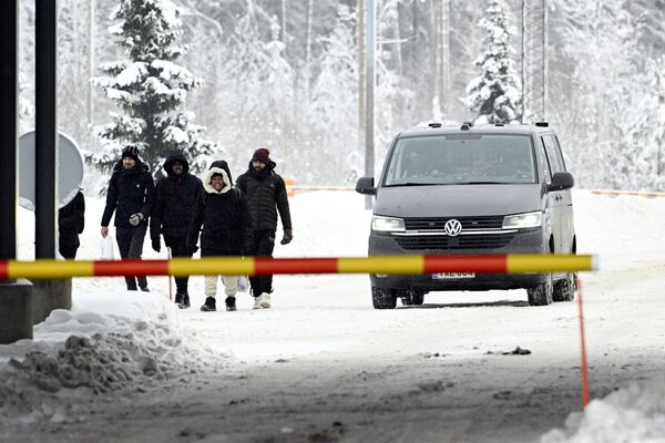 Группа мигрантов, пересекающих российско-финскую границу. - Sputnik Латвия