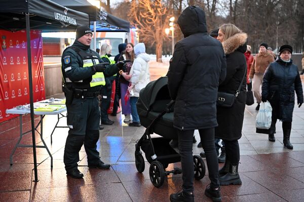 На фото: сотрудники полиции рассказывают жителям о правилах безопасности в зимнее время года.  - Sputnik Латвия