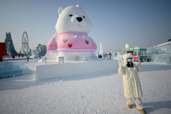 Фестиваль в Харбине является крупнейшим в мире. Десятками огромных ярких и разноцветных ледяных скульптур любуются посетители.На фото: женщина позирует на выставке Harbin Ice and Snow World в Харбине. - Sputnik Латвия