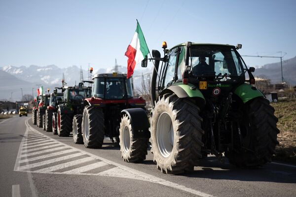 В Италии фермеры протестуют, по выражению национальной прессы, &quot;пятнами леопарда&quot; и дороги пока не перекрывают. На фото: тракторы протестующих на обочине трассы в Пьемонте. - Sputnik Латвия