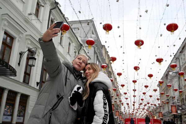 Девушки фотографируются в Камергерском переулке, украшенном в честь празднования китайского Нового года в Москве - Sputnik Латвия