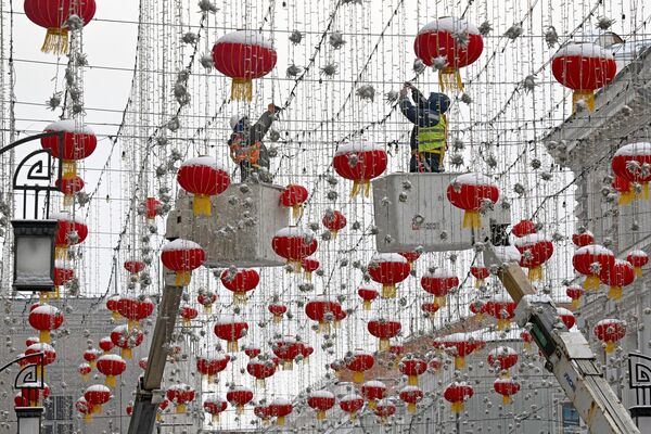 Рабочие устанавливают украшения в Камергерском переулке в честь празднования китайского Нового года в Москве. - Sputnik Латвия