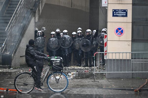Мужчина едет на велосипеде мимо сотрудников полиции в Брюсселе - Sputnik Латвия