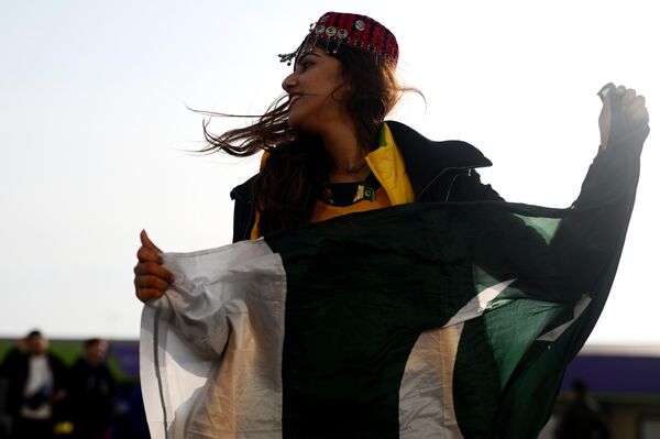 Участница из Пакистана фотографируется с национальным флагом. - Sputnik Латвия