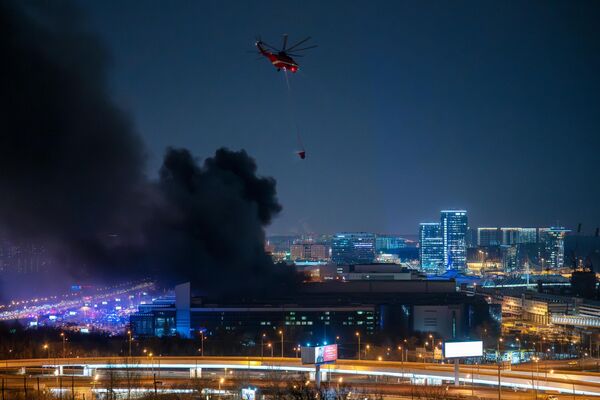 Пожарный вертолет во время тушения горящей крыши концертного зала Крокус Сити Холл - Sputnik Латвия