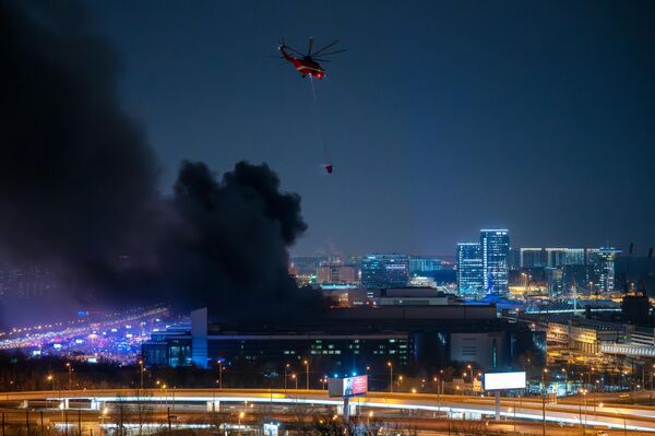 Пожарный вертолет во время тушения горящей крыши концертного зала Крокус Сити Холл - Sputnik Латвия