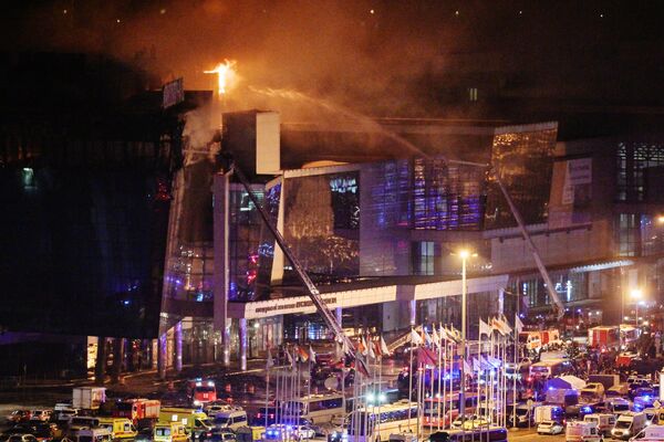 Пожарные тушат горящий концертный зал Крокус Сити Холл, где произошла стрельба - Sputnik Латвия