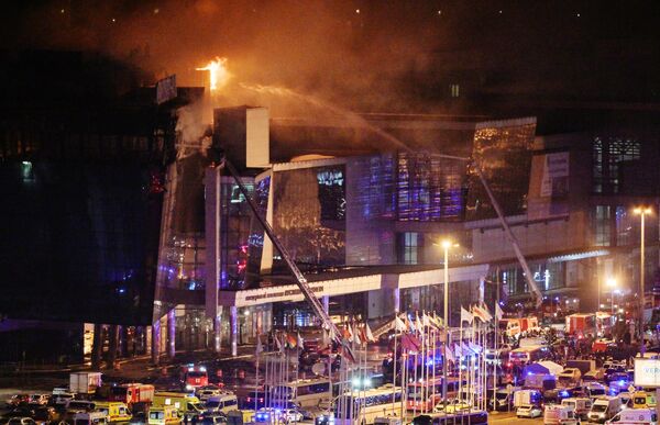 Пожарные тушат горящий концертный зал Крокус Сити Холл, где произошла стрельба - Sputnik Латвия