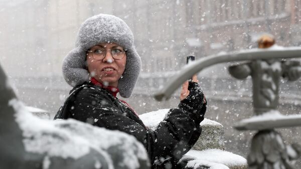 Женщина делает селфи во время сильного снегопада в пятницу в Петербурге  - Sputnik Латвия