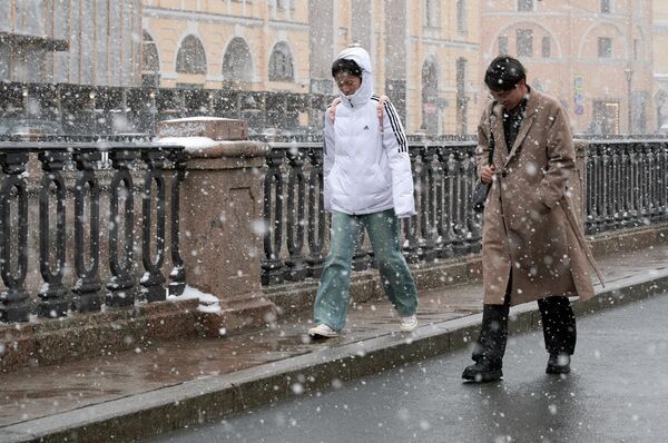 Пара гуляет в снегопад.  - Sputnik Латвия