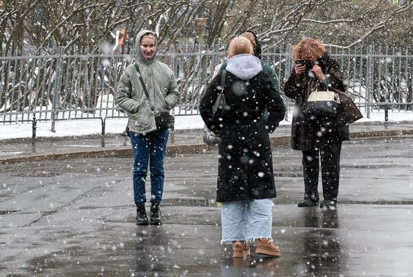 Одевшись потеплее, люди гуляют по улицам или спешат по своим делам.  - Sputnik Латвия
