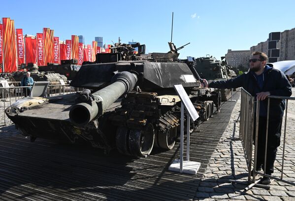 Посетитель фотографирует трофейный танк Abrams американского производства на выставке на Поклонной горе - Sputnik Латвия