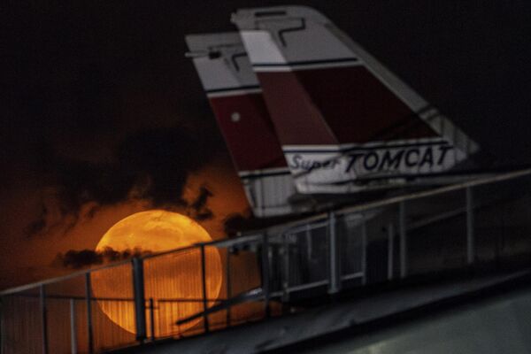 Цветочная луна садится за истребители Grumman F-14 Tomcat в музее &quot;Интрепид&quot; в Нью-Йорке. - Sputnik Латвия