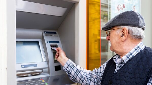 Пожилой мужчина стоит у банкомата - Sputnik Латвия