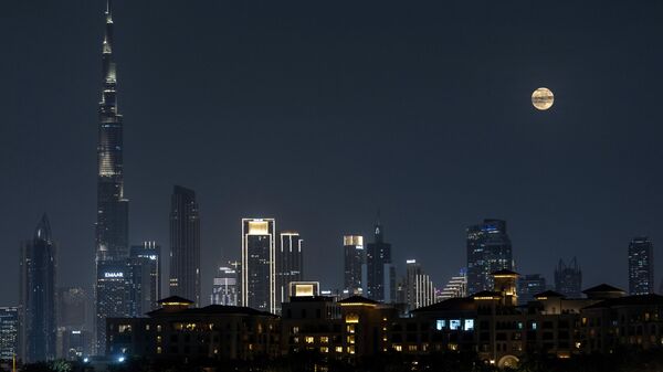 Полная луна поднимается над города и самой высокой башней в мире, Бурдж-Халифа, в Дубае, ОАЭ - Sputnik Латвия
