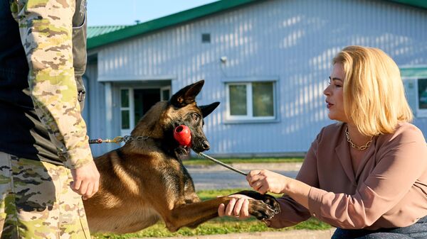 Премьер-министр Латвии Эвика Силиня во время рабочего визита в Резекне играет со служебной собакой  - Sputnik Латвия