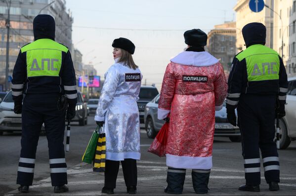 Сотрудники Госавтоинспекции в костюмах Деда Мороза и Снегурочки поздравляют водителей с наступающим Новым годом во время акции Полицейский Дед Мороз на площади Ленина в Новосибирске - Sputnik Латвия