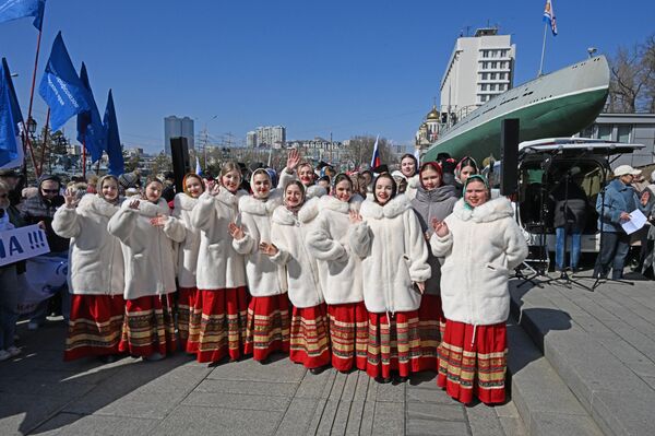 Участницы митинга-концерта в день одиннадцатой годовщины воссоединения Крыма с Россией у мемориала Боевая слава Тихоокеанского флота на Корабельной набережной во Владивостоке - Sputnik Латвия
