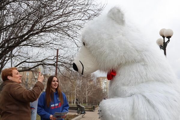 Активисты ДРОО Молодая Республика поздравляют людей в честь годовщины воссоединения Крыма с Россией в Донецке - Sputnik Латвия