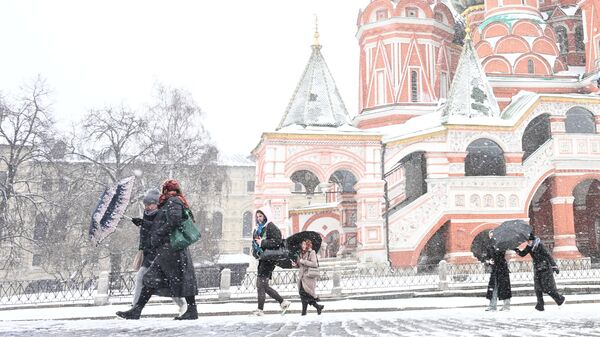 Люди на Красной площади во время снегопада в Москве - Sputnik Латвия