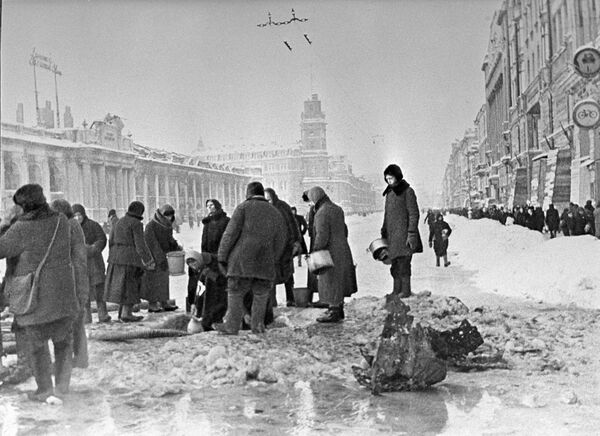 Голод, холод, непрекращающиеся бомбежки... Но Ленинград не сдавался. Блокаду удалось прорвать 18 января 1943 года, а еще примерно через год – 27 января 1944-го – ее полностью сняли.На фото: жители блокадного Ленинграда набирают воду из пробитого при обстреле водопровода. Голод, холод, непрекращающиеся бомбежки... Но Ленинград не сдавался. Блокаду удалось прорвать 18 января 1943 года, а еще примерно через год – 27 января 1944-го – ее полностью сняли.На фото: жители блокадного Ленинграда набирают воду из пробитого при обстреле водопровода. - Sputnik Латвия