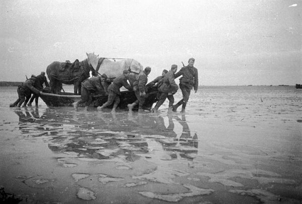 1 ноября 1943 года началась операция по форсированию Сиваша. Самым трудным было то, что дно его чрезвычайно илистое, вода очень низкой температуры. Лошади, повозки переходить вброд не могли, и все оружие, боеприпасы красноармейцам приходилось тащить на себе. Советские полки закрепились на занятой территории, с ходу захватили плацдарм на южном берегу Сиваша, но дальше прорваться не смогли. Бои на этом участке продолжались до апреля 1944 года, когда Красная Армия начала решительную операцию по освобождению Крыма.На фото: форсирование озера Сиваш. 1 ноября 1943 года началась операция по форсированию Сиваша. Самым трудным было то, что дно его чрезвычайно илистое, вода очень низкой температуры. Лошади, повозки переходить вброд не могли, и все оружие, боеприпасы красноармейцам приходилось тащить на себе. Советские полки закрепились на занятой территории, с ходу захватили плацдарм на южном берегу Сиваша, но дальше прорваться не смогли. Бои на этом участке продолжались до апреля 1944 года, когда Красная Армия начала решительную операцию по освобождению Крыма.На фото: форсирование озера Сиваш. - Sputnik Латвия