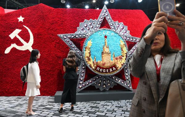 Особое внимание привлек стенд "Уралхима" и огромное панно из тысячи живых цветов, посвященное Великой Победе. Особое внимание привлек стенд "Уралхима" и огромное панно из тысячи живых цветов, посвященное Великой Победе. - Sputnik Латвия