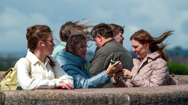 Горожане на набережной реки Невы во время ветреной погоды в Санкт-Петербурге - Sputnik Латвия