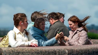 Горожане на набережной реки Невы во время ветреной погоды в Санкт-Петербурге